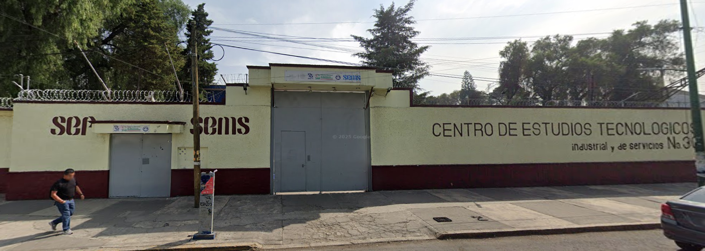 Fotografía en la que se muestra la fachada del plantel, conformada por dos muros color amarillo que, en la parte inferior, tienen una franja de color rojo. En medio de los muros hay un portón color gris que da acceso al plantel. El muro que está al lado derecho del portón tiene escrito en letras rojas grandes CENTRO DE ESTUDIOS TECNOLÓGICOS INDUSTRIAL Y DE SERVICIOS NÚMERO 30. 
